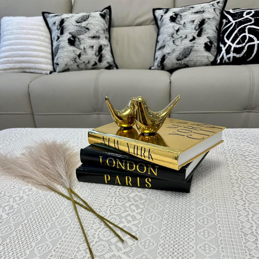 Black and Gold Decorative Books with Small Gold Bird Statues 